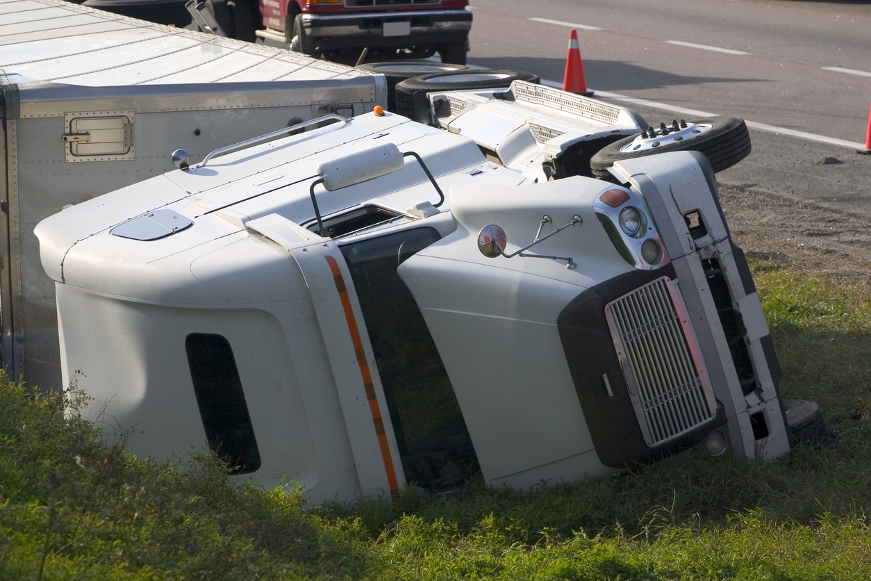 Which factors can contribute to truck rollover accidents?